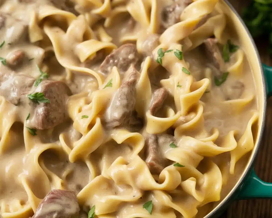 Creamy beef stroganoff crock pot dish served over egg noodles with mushrooms.