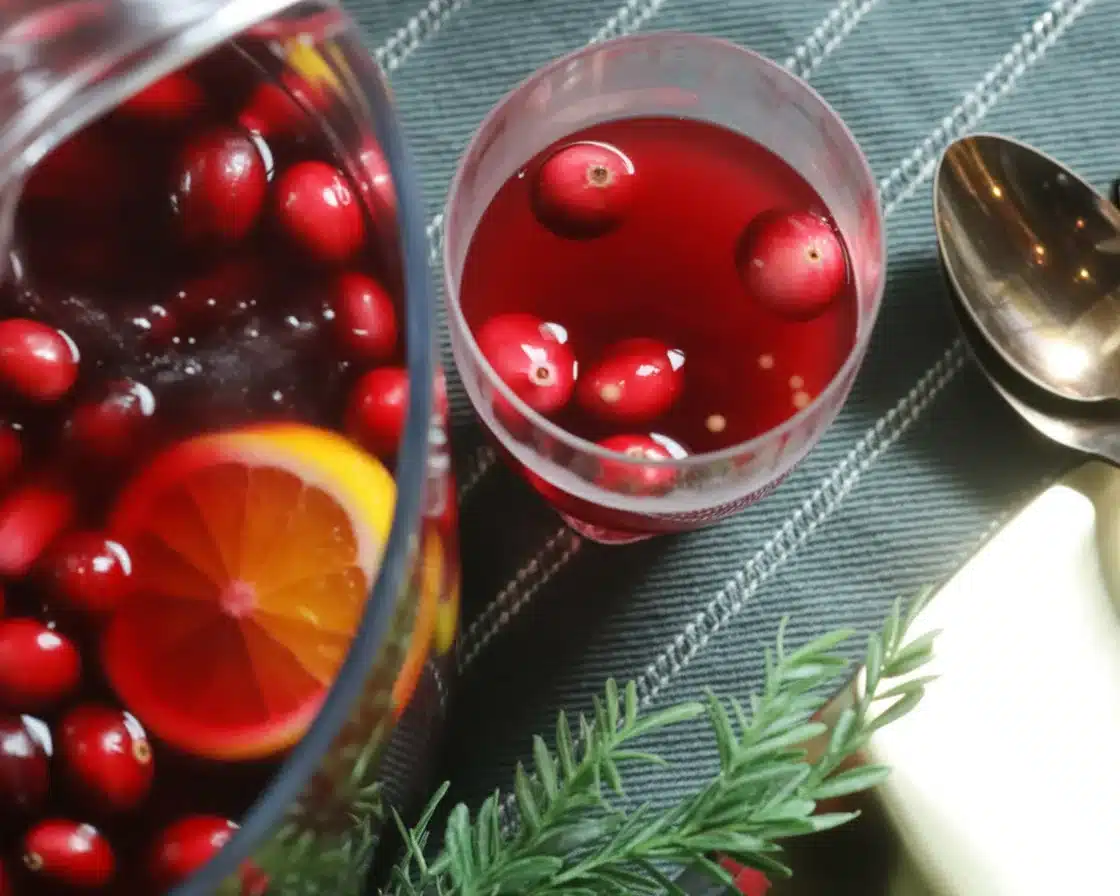 A festive Wassail holiday punch with spices and fruit garnished in a punch bowl.