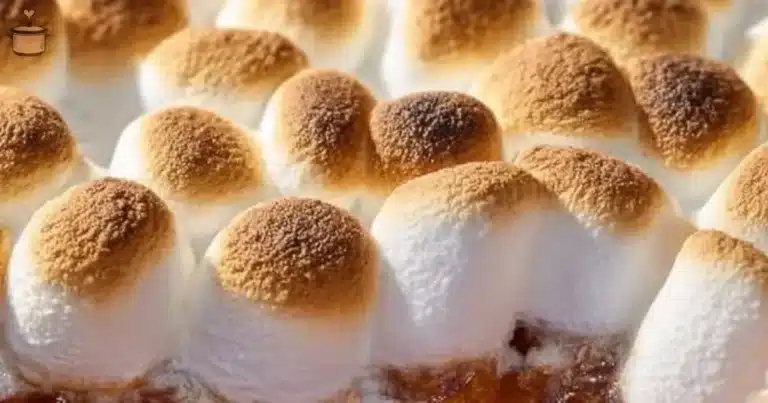 Sweet potato casserole topped with marshmallows and pecans on a serving dish