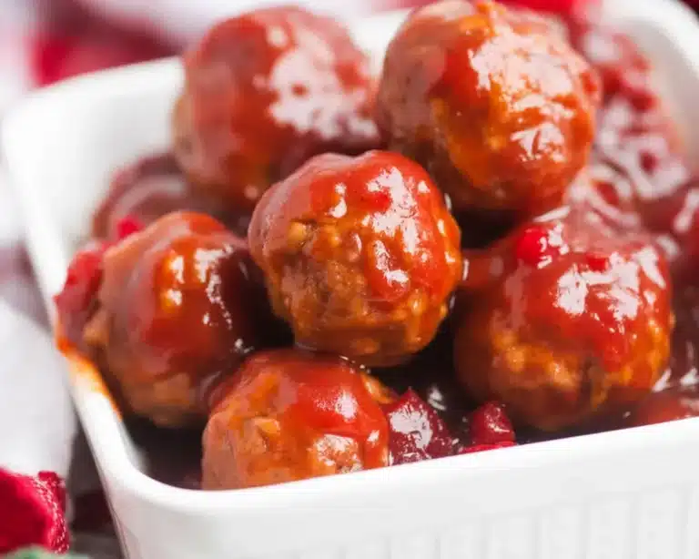 Crockpot cranberry meatballs with cranberry sauce and chili sauce in a slow cooker.
