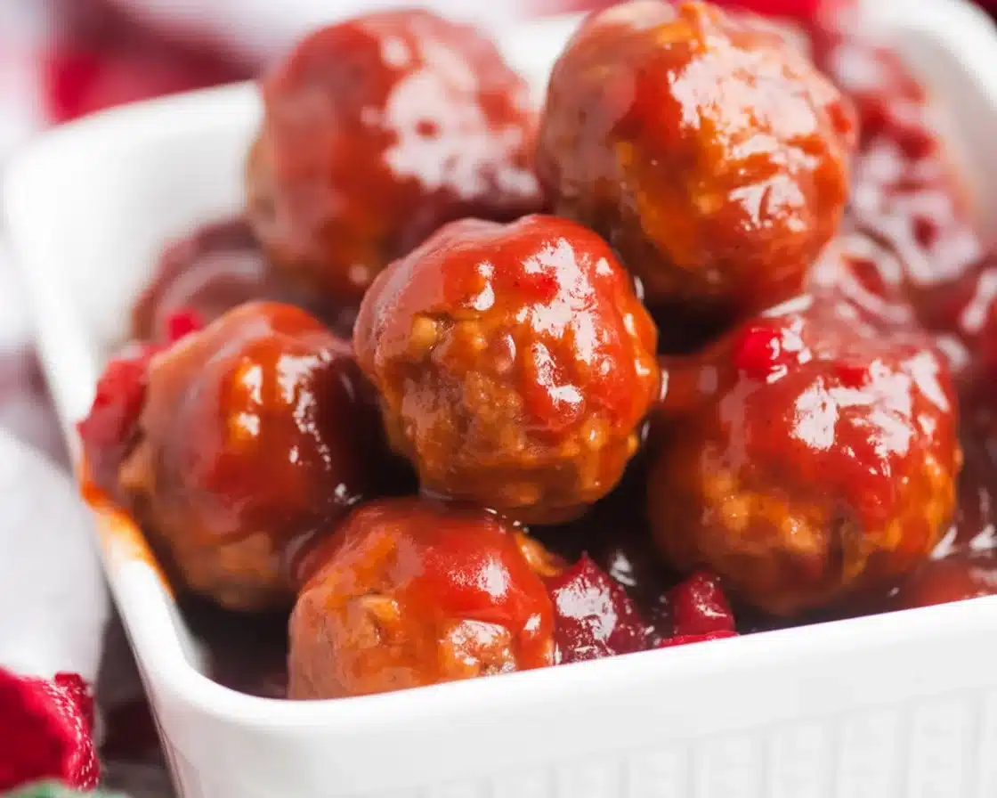 Crockpot cranberry meatballs with cranberry sauce and chili sauce in a slow cooker.