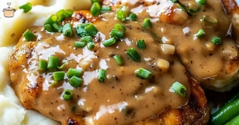 Delicious easy stovetop smothered chicken with creamy gravy served on a plate.