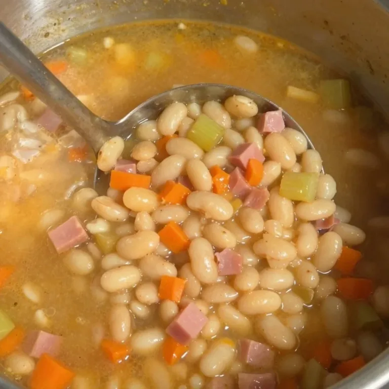 Bowl of homemade ham and bean soup, garnished with fresh herbs
